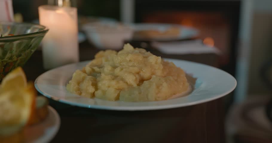 Close-up Dish of Mashed Potato Puree on Table Near Fireplace. 4K 10-bit