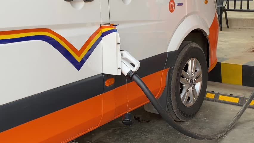 Electric van charging at station in outdoor parking area near veterinary company entrance