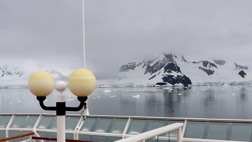 Antarctica icy landscape with glaciers and mountains viewed from expedition cruise ship deck
