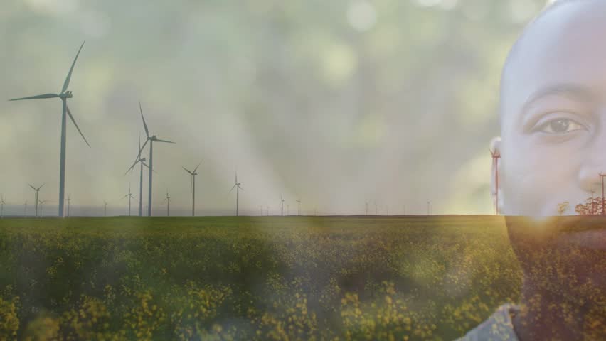 Portrait overlay fading in, male portrait growing opaque as turbines rotating, showing clean energy. Windfarm, horizon, rural, grassland, meadow, sunflare, bokeh