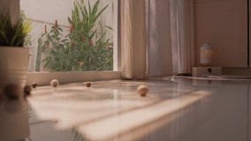 Fat gray tabby American Shorthair cat walks in, looks at camera, then bats at scattered ball toys with one paw. Golden morning sunlight and a candle lantern create a cozy peaceful home mood. - Powered by Shutterstock - Get 15% off with code: PIKWIZARD15