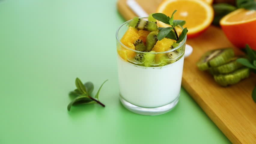 healthy breakfast yogurt with fresh kiwi and orange topping