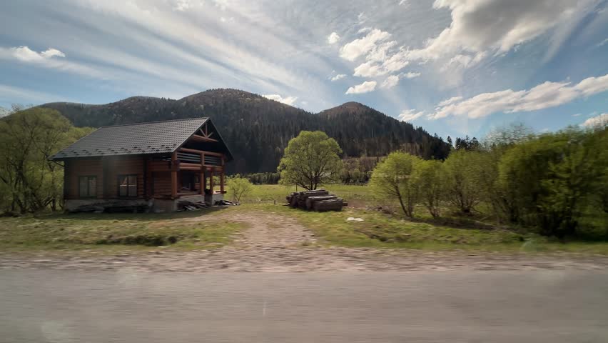 Rolling landscape with hills and trees along the roadside in a rural area during daytime in spring