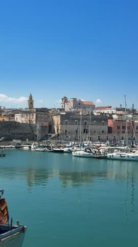 Bisceglie marina and waterfront with sailboats moored in the harbor and historic old town in the background, Apulia, Southern Italy – panoramic view of the Adriatic coast on a sunny day