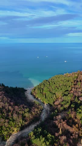 Aerial drone view of a river flowing through forest into the Black Sea at Abana Catalzeytin border in Kastamonu Turkey scenic untouched nature with coastline and calm sea