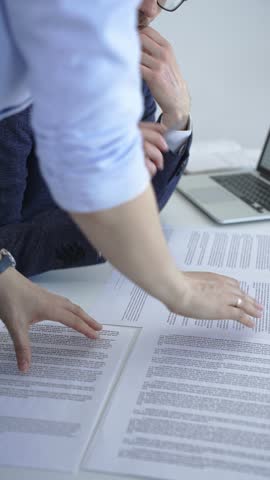 Business professionals engaging in a collaborative discussion, reviewing important documents and contracts, and working together on a project in an office setting