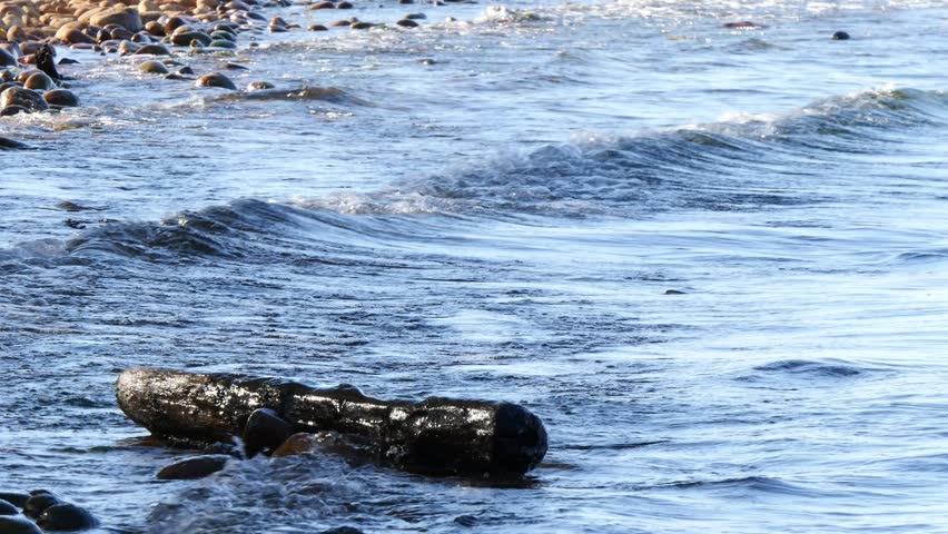 The rocky coast of Lake Baikal, dotted with unusual round, multi-colored boulders with beautiful carved patterns.