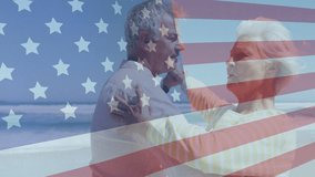 Senior couple celebrating 4TH on shore twirling into embrace as faint flag overlay rising over them. Mature, duo, dance, patriotic, romance, beach, ocean - Powered by Shutterstock - Get 15% off with code: PIKWIZARD15