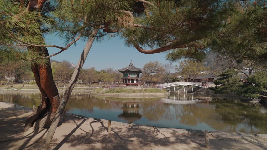 Hyangwonjeong Pavilion located in Gyeongbokgung Palace Seoul South Korea. Traditional Korean pavilion surrounded by water with scenic reflections, bridge, and peaceful atmosphere during daytime.