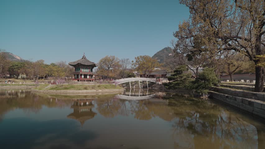 Hyangwonjeong Pavilion located in Gyeongbokgung Palace Seoul South Korea. Traditional Korean pavilion surrounded by water with scenic reflections, bridge, and peaceful atmosphere during daytime.