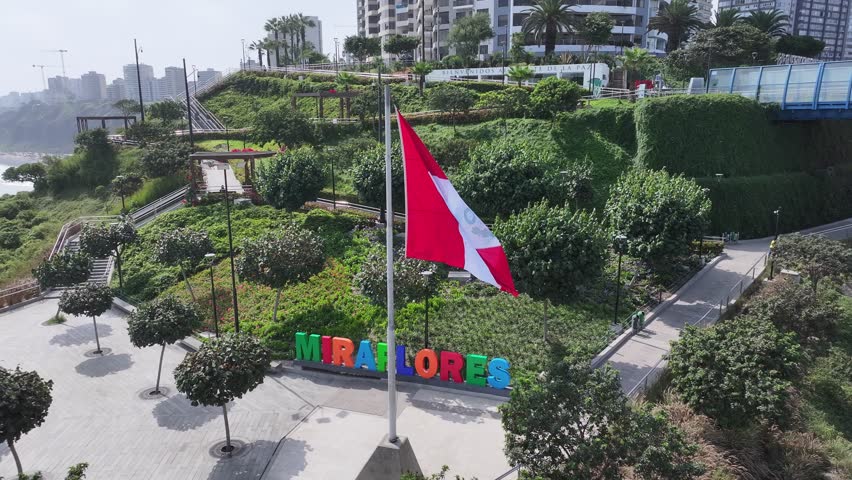 Miraflores Sign In Metropolitan Region Of Lima In Peru. Peru Flag Waving. Green Coast Landscape. Travel Destination. Miraflores Sign In Metropolitan Region Of Lima In Peru. Flag Of Peru Waving.