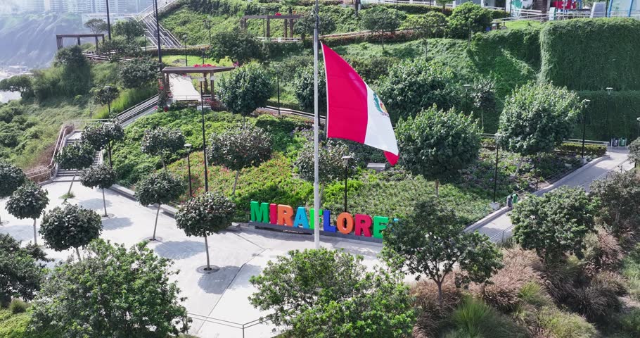 Miraflores Sign In Metropolitan Region Of Lima In Peru. Peru Flag Waving. Green Coast Landscape. Travel Destination. Miraflores Sign In Metropolitan Region Of Lima In Peru. Flag Of Peru Waving.
