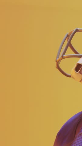 Vertical video: Player catching football from left, cam zooming, rings tracking grip, showing catch. Athlete, helmet, jersey, purple, studio, gradient, vertical video