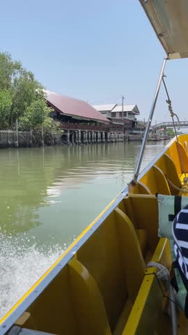 View from a long-tail boat moving along the canal, passing through a mangrove forest and several traditional Thai houses. - Water Transportation, Thai local Transportation, vertical video - Bangkok, Thailand

