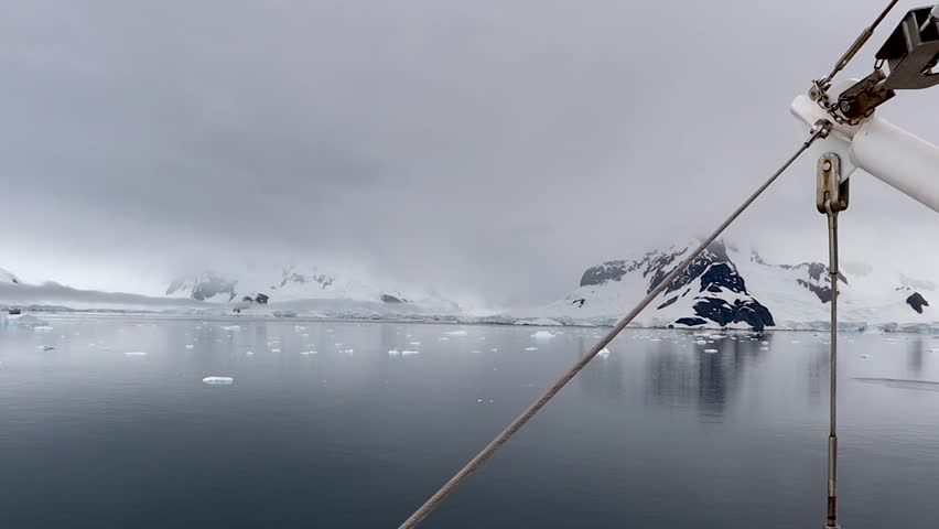 Antarctic landscape with icebergs and snowy mountains viewed from expedition ship