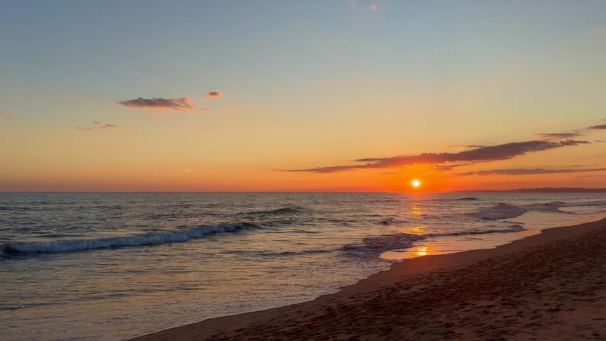 Golden sunset over ocean horizon showing calm natural seascape and open sky