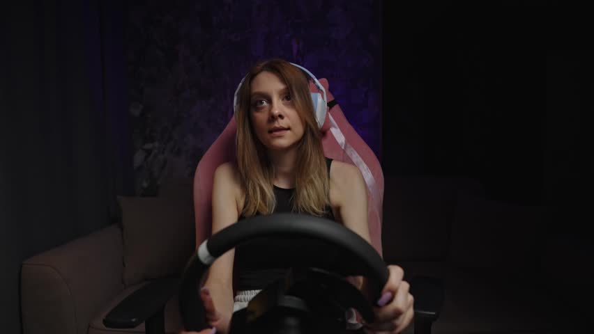 Intense Sim Racing White Woman Gripping Wheel, Headset And Pink Chair In Dark Studio, Focused Expression