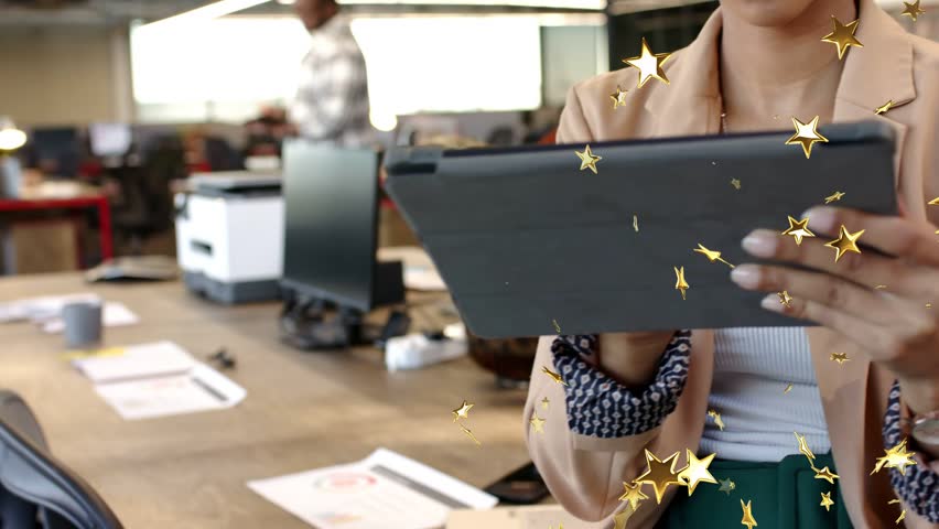 Businesswoman tapping and scrolling tablet in office reviewing files and causing gold stars overlay. Woman, professional, confetti, workspace, device, focus, collaboration