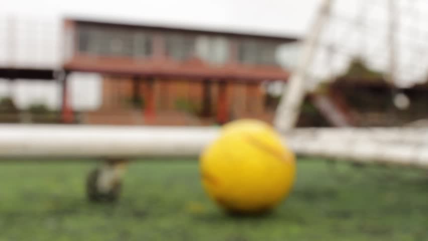 A yellow ball lies on a soccer field with stands in the background of a stadium in Neiva, Huila, Colombia. Concept of sports and objects