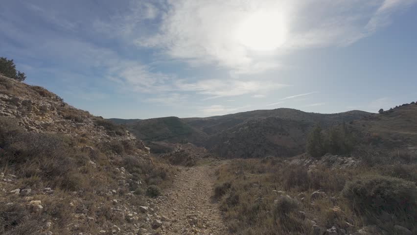 Point of view hiking on a mountain trail during a sunny day