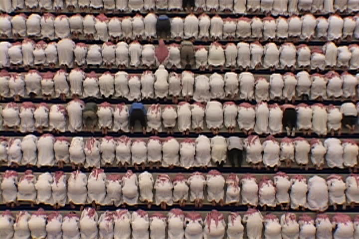RIYADH, SAUDI ARABIA - OCTOBER 01, 2002: Overhead view of university mosque. Hundreds of men dressed in white, with red and white checked keffiyeh, standing and bowing in unison. | Shutterstock HD Video #4065628