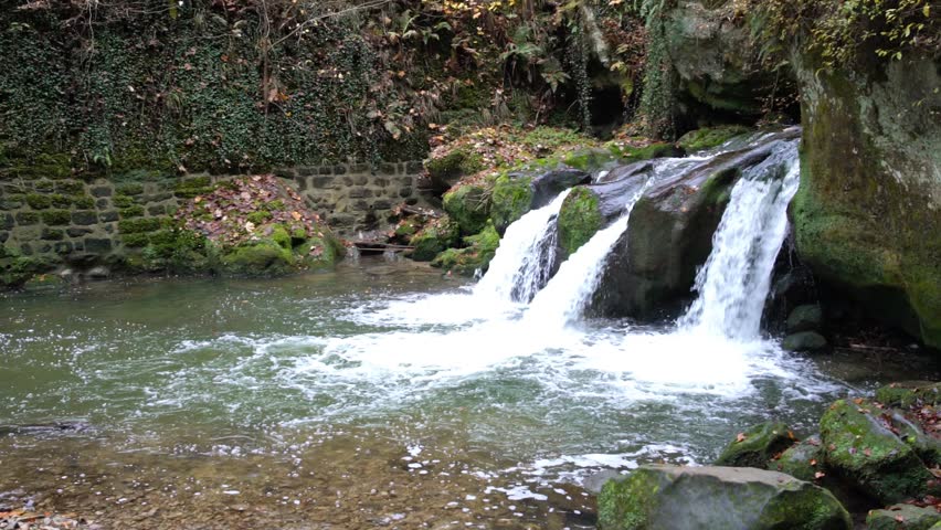 deep in the forest there is a small waterfall in switzerland in Luxembourg