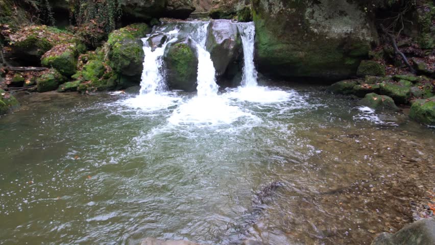 deep in the forest there is a small waterfall in switzerland in Luxembourg