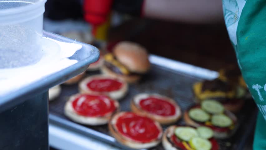 Delicious burgers on grill with ketchup and mustard
