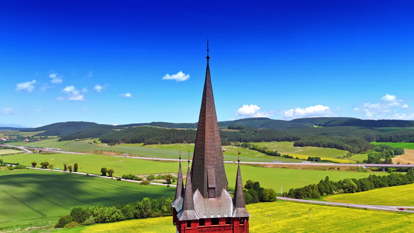 Footage at the steeple of the old church. Aerial perspective on the picturesque countryside in Slovakia.