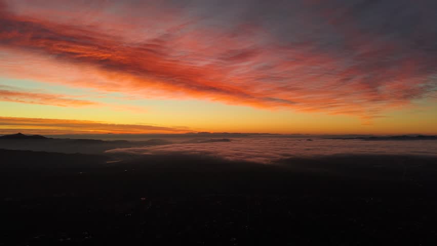 Vibrant, multicolored sunrise as seen from the summit of a mountain.