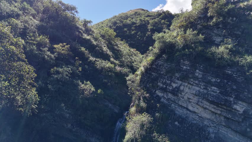 Waterfall falling into a narrow rocky gorge, forming a double drop.