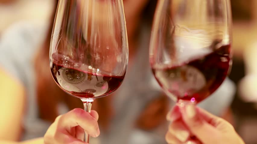 Close up on wine glasses swirling, toasting, drinking.