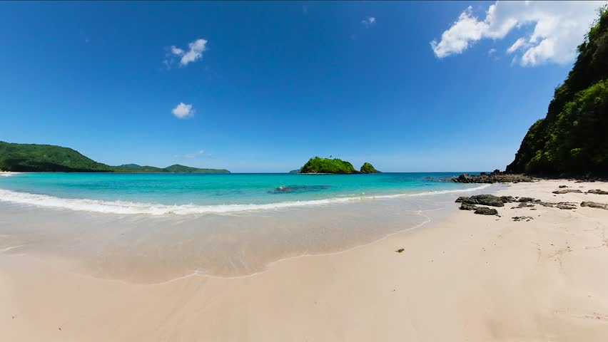 Tropical Beach with clear sea waves on sandy beach. Nacpan Beach. El Nido. Palawan. Philippines.