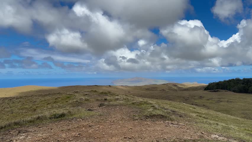 View of the grasslands and the Pacific Ocean from the summit of Terevaka Mountain on Easter Island, pan shot, mid-November 2025.
