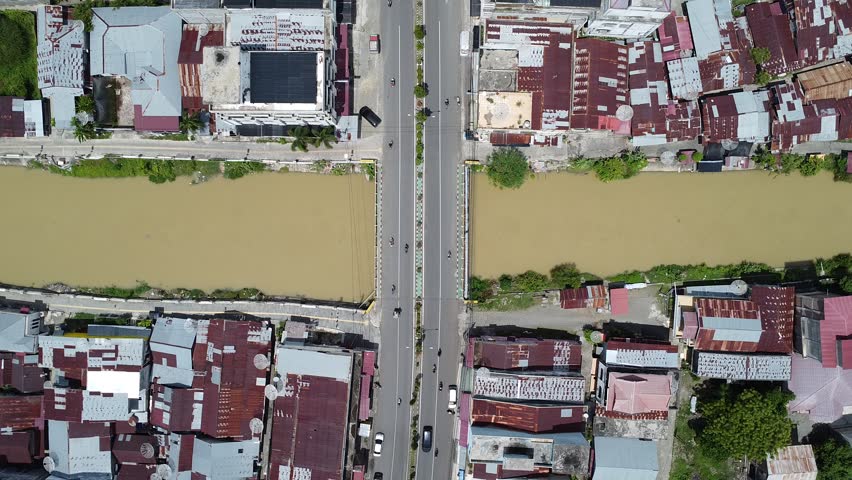 Aerial top-down view of a city bridge over a muddy river