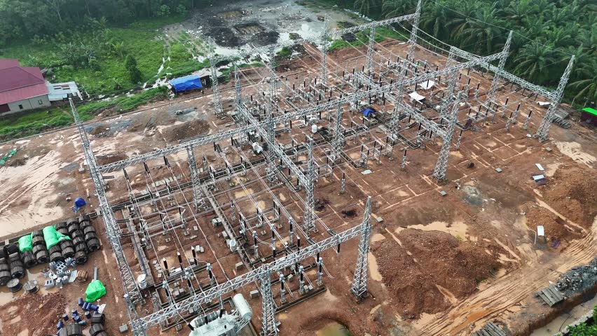 Aerial View of the Construction of a Electrical Substation and Transformers Near Oil Palm Plantation Infrastructure.