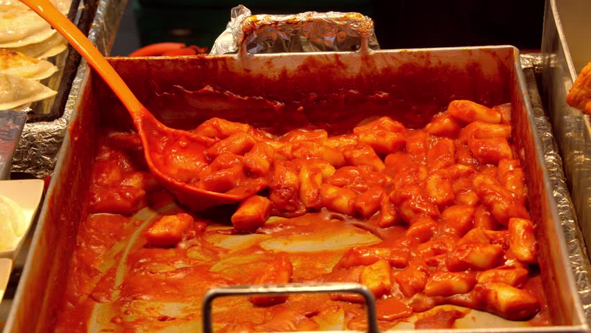 Tteokbokki rice cakes simmering in spicy gochujang sauce at a Seoul street food stall