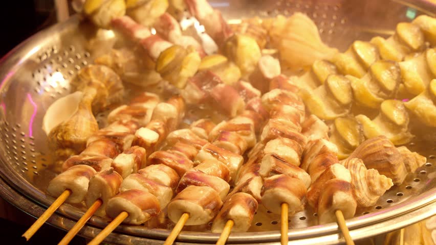 Steaming seafood skewers and shellfish for sale at a Korean street food stall