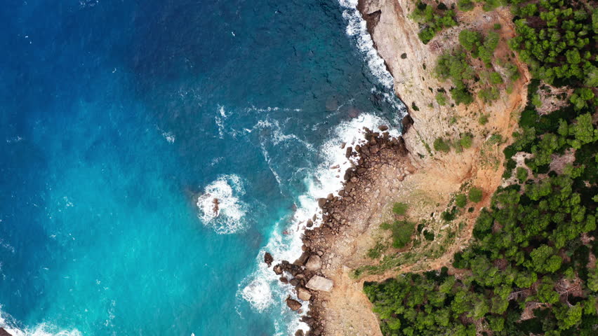 Aerial view of nature landscapes of Mallorca island in Spain. Mediterranean sea waves crashing on rocky shore, travel and tourism in Europe.