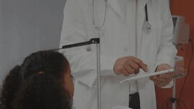 Doctor tapping tablet causing health charts to grow over exam while reading data, child watching. Clinician, pediatric, analytics, visualization, dashboard, monitoring, stethoscope - Powered by Shutterstock - Get 15% off with code: PIKWIZARD15