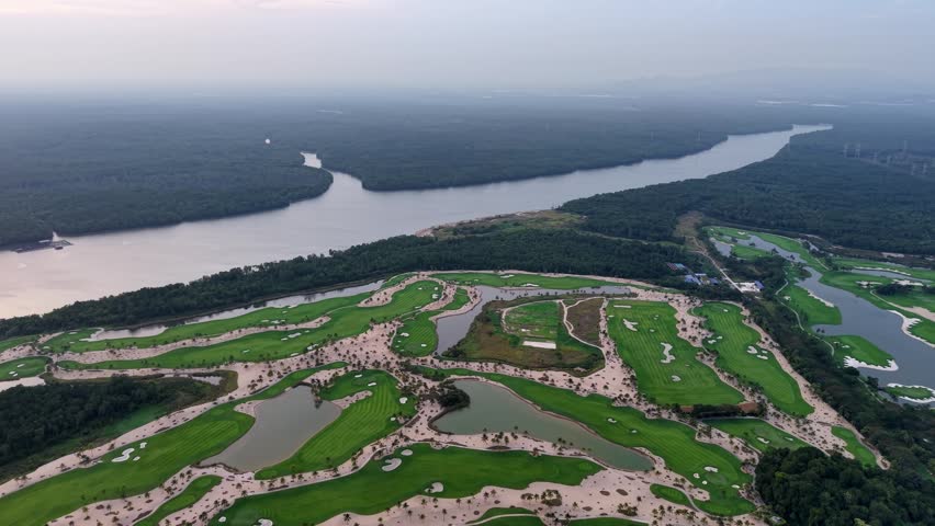 Drone aerial view showcasing golf course layout, lakes and surrounding mangrove river landscape at Forest City Resort.