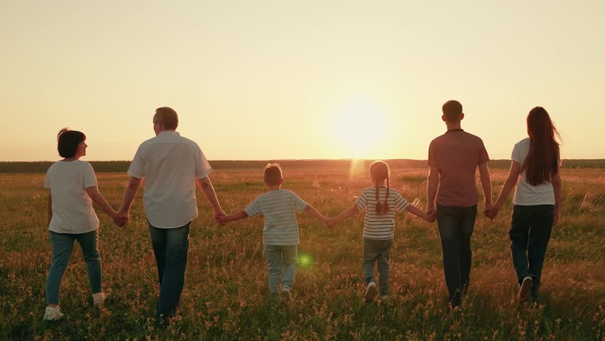 Large group people strolling green grass in summer. Parents father mother, children walking, sun meadow. Happy family, kid go field in countryside. Dad mom, kids son daughter together, nature, sky