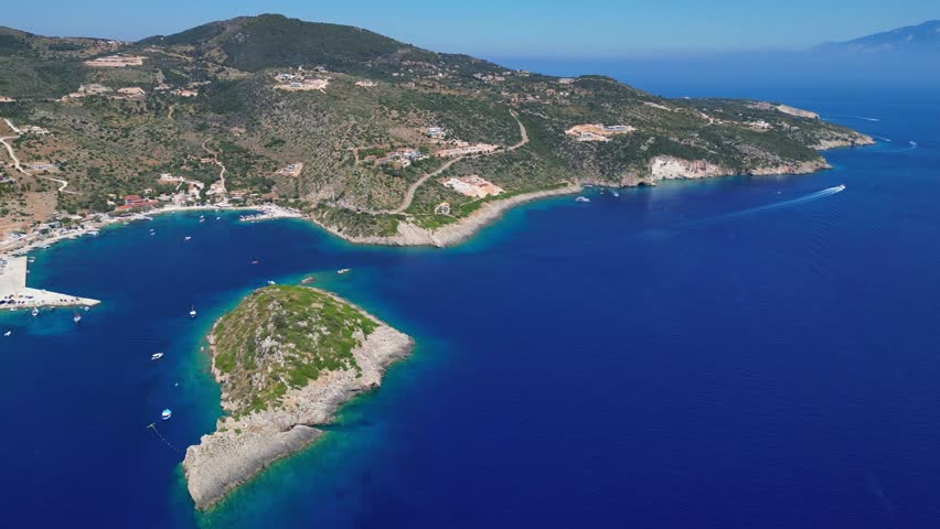 Scenic view of Agios Nikolaos port in Zakynthos with crystal blue water, sea caves, and a historic monastery rock. Beautiful Greek island landscape with tourist boats in the Ionian Sea.