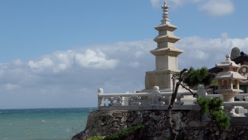 Stone Buddhist pagoda and temple architecture standing on a cliff by the deep blue sea