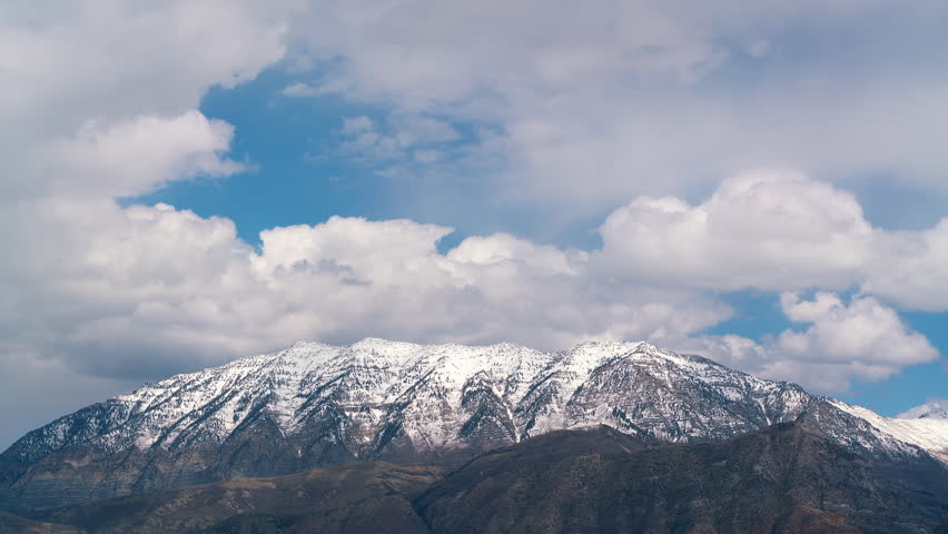 Time lapse of clouds moving over snow-capped Cascade Mountain in Utah.