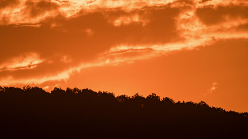 Peaceful morning time-lapse of sunrise in the mountains, soft clouds moving over a high altitude landscape.