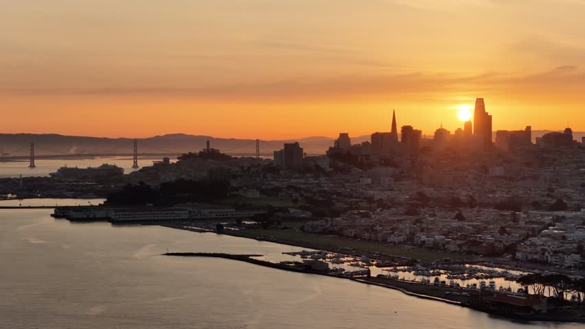 Golden sunset over San Francisco skyline with Bay Bridge and glowing bay waters. g.
