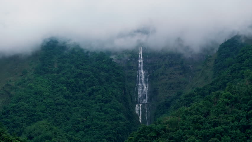 Aerial view misty foggy mountain landscape with clouds and waterfall
