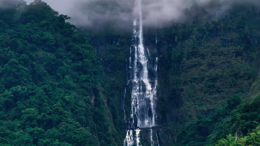 Aerial view misty foggy mountain landscape with clouds and waterfall