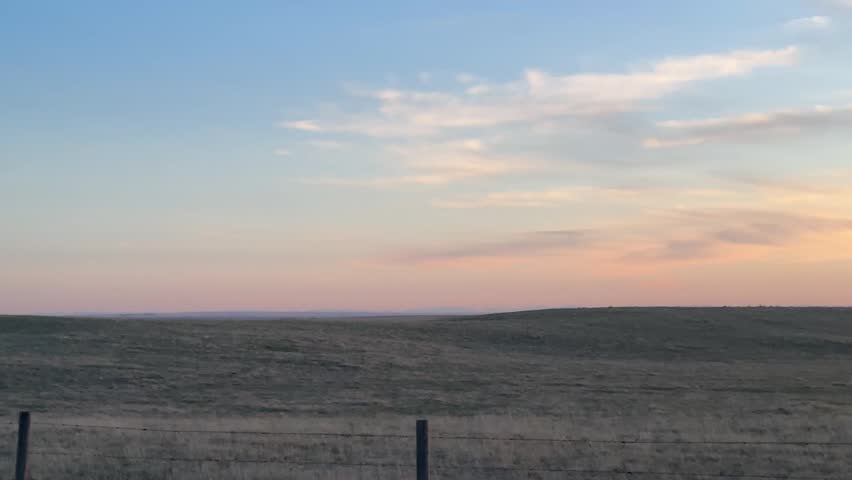 Expansive farmland landscape with open agricultural fields and wide prairie horizon under natural light In Gleichen Alberta